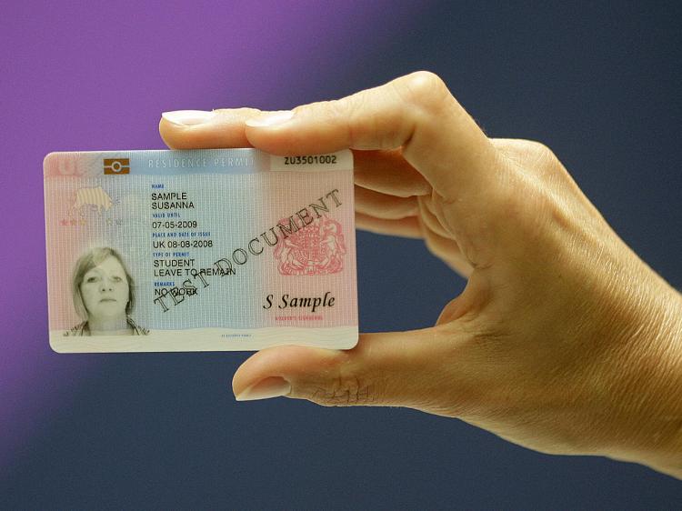 A British Home Office employee displays an official British biometric ID card at a press conference in London, on September 25, 2008.    (Shaun Curry/AFP/Getty Images)