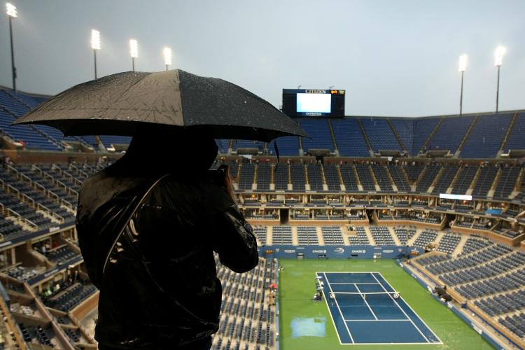 A fan stands under an umbrella as play is suspended due to rain during the men's singles final match between Novak Djokovic of Serbia and Rafael Nadal of Spain on day fifteen of the 2010 U.S. Open at the USTA Billie Jean King National Tennis Center on September 13, 2010 in the Flushing neighborhood of the Queens borough of New York City. (Al Bello/Getty Images) A fan stands under an umbrella as play is suspended due to rain during the men's singles final match between Novak Djokovic of Serbia and Rafael Nadal of Spain on day fifteen of the 2010 U.S. Open at the USTA Billie Jean King National Tennis Center on September 13, 2010 in the Flushing neighborhood of the Queens borough of New York City. (Al Bello/Getty Images)