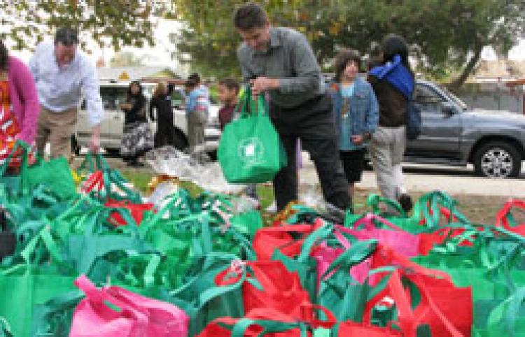 Children and parent volunteers for CHPHP deliver 'Thanksgiving In A Bag' gifts for the homeless people in their community. (Courtesy of CHPHP)