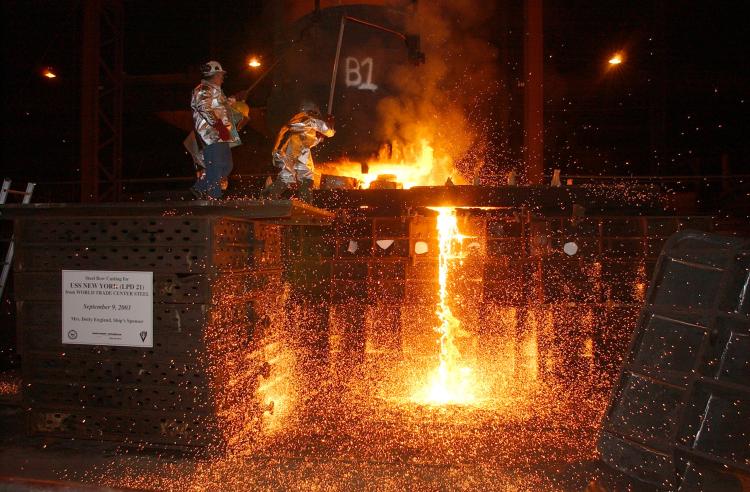 In this file handout photo, workers pour steel, recycled from the World Trade Center, into a mold, which will form the bow stem of the Amphibious Transport Dock ship USS New York at Amite, Louisiana. USS New York set sail from Louisiana to New York City t (George Trian/U.S. Navy via Getty Images)