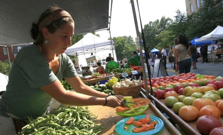 A vendor cuts heirloom tomatoes to serve as samples for potential customers at a farmer's market in Washington, D.C. Small farmers selling direct to consumers, restaurants, and hotels are exempt from new regulations recently passed in the Food Safety Mode (Abdullah Pope/AFP/Getty Images)