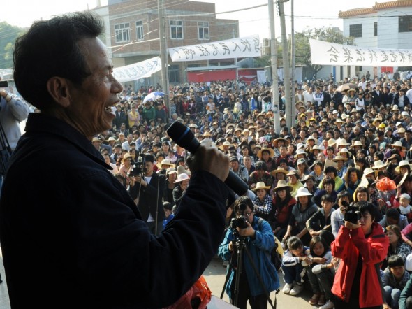 Wukan villagers listen to a speech by village leader