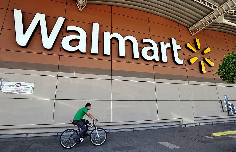 A man rides his bike past a Walmart store in Mexico City, Mexico