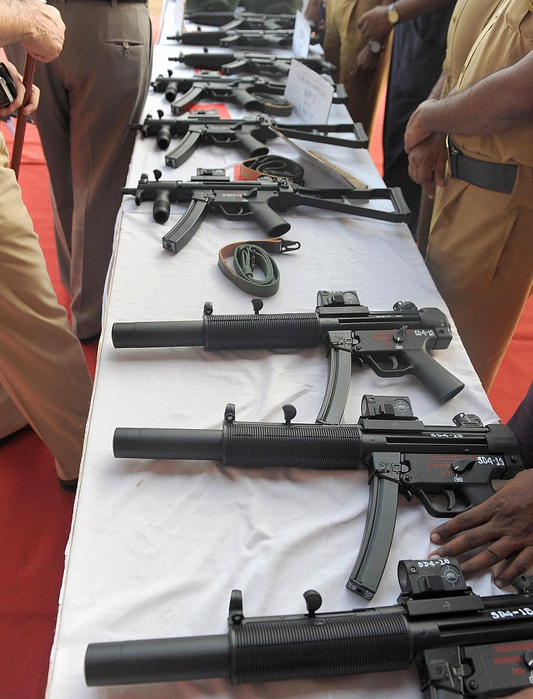 Indian policemen inspect various imported automatic weapons
