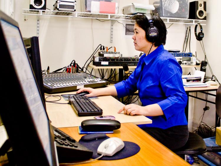 Yue Chen sits at her computer, part of the modest set-up at Sound of Hope's Manhattan office. She has been with the broadcaster, which focuses on human rights in China, since its inception in 2003.  (Matthew Robertson/The Epoch Times)