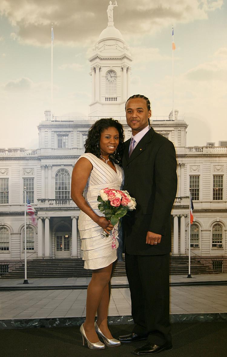 NEWLY WEDS: Trevor and Anthea Neale were married on Monday at the stylish new marriage bureau in downtown Manhattan, a couple of blocks up from the old City Hall location. They pose for family in front of the City Hall backdrop. (Katy Mantyk/Epoch Times)