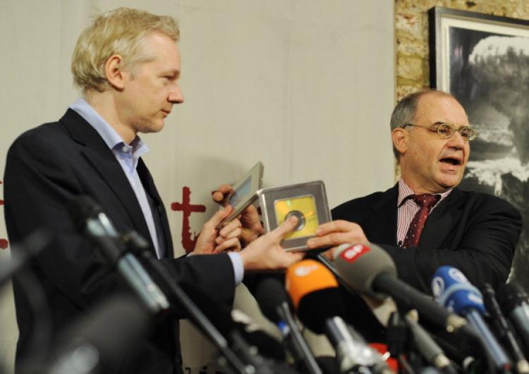 Former Swiss banker Rudolf Elmer (R) gives WikiLeaks founder Julian Assange (L) two CDs following a press conference in London, on January 17, 2011.  (Ben Stansall/AFP/Getty Images)
