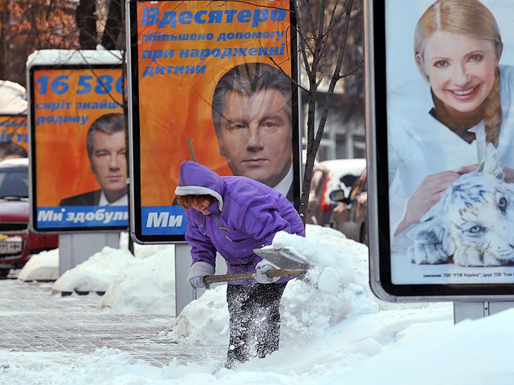 A woman clears a snow near election posters for Presidential candidates Ukraine's President Viktor Yushchenko (L) and the Prime Minister Yulia Tymoshenko (R) in Kiev on December 21, 2009. (Sergei Supinsky/AFP/Getty Images)