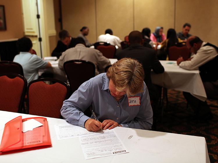 A job seeker fills out a job application during a job fair. (Justin Sullivan/Getty Images)