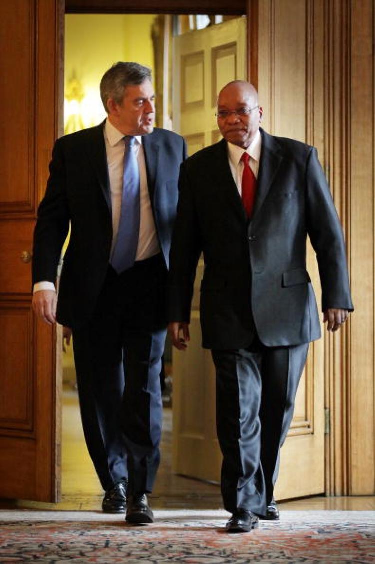 British Prime Minister Gordon Brown (L) and South African President Jacob Zuma (C) arrive for a press conference in London on Thursday. Brown insisted that Zimbabwe should make more progress before sanctions can be lifted, resisting pressure from Zuma.