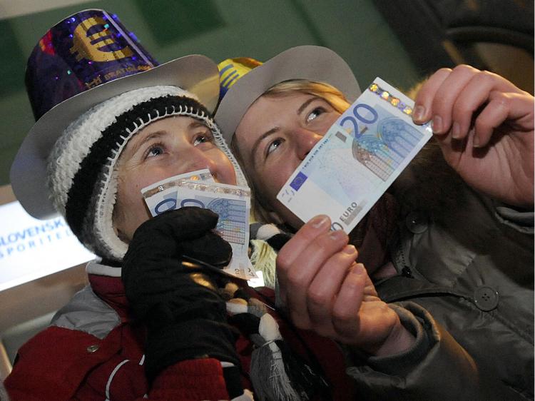 People celebrate after collecting their first twenty euros from a cash machine in the centre of Bratislava's main square on January 1,2009, after Slovakia joined the eurozone.    (Samuel Kubani/AFP/Getty Images)