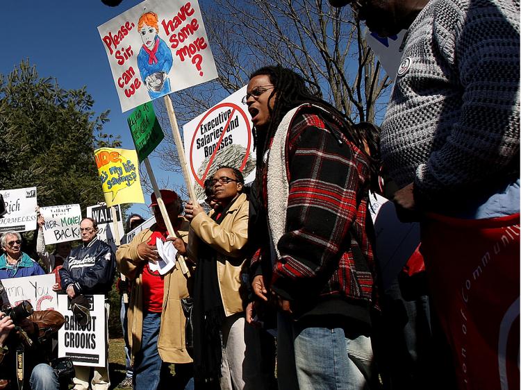 Protesters stand in front of the Financial Products Headquarters of AIG protesting the more than 400 executives at AIG who were paid $165 million in bonuses.   (Spencer Platt/Getty Images)