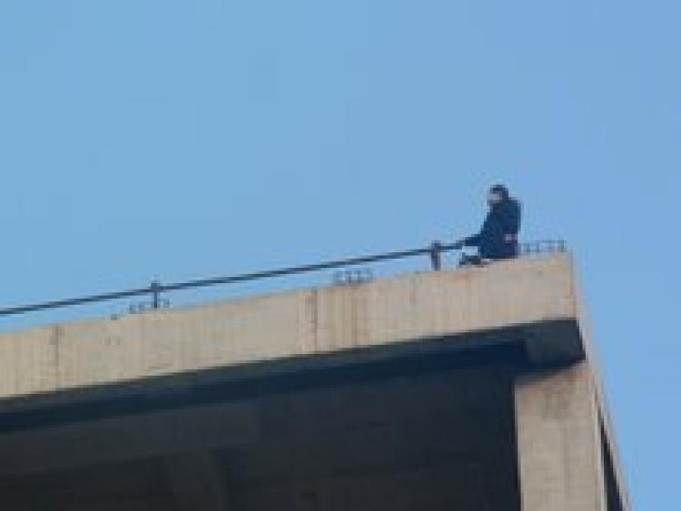 Pregnant petitioner Zhao Chunhong climbed to the top of a tall building in Beijing, hung a banner, scattered leaflets and even sought to jump off the building all in protest of corrupt officials.  (The Epoch Times)