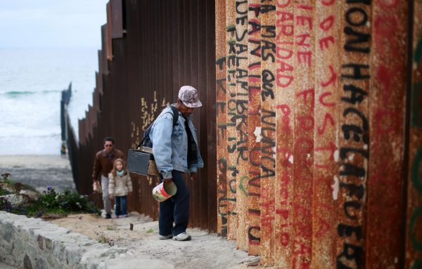 A man walks along the U.S.-Mexico border wall in Tijuana, Mexico, on Feb. 22, 2015. (Sandy Huffaker/Getty Images)