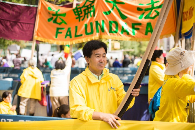 Falun Gong practitioners hold banners and perform exercises to raise awareness about the persecution inside China that is now in its 18th year at the Dag Hammarskjold Plaza near the United Nations headquarters in New York on Sept. 19, 2017. (Benjamin Chasteen/The Epoch Times)