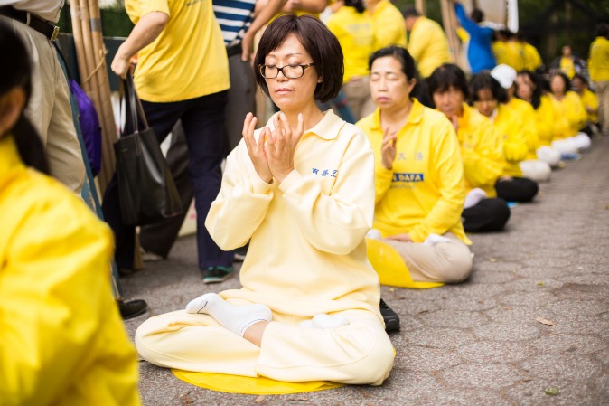 Falun Gong practitioners meditate to raise awareness about the persecution inside China that is now in its 18th year at the Dag Hammarskjold Plaza near the United Nations headquarters in New York while the world leaders meet on Sept. 19, 2017. (Benjamin Chasteen/The Epoch Times)