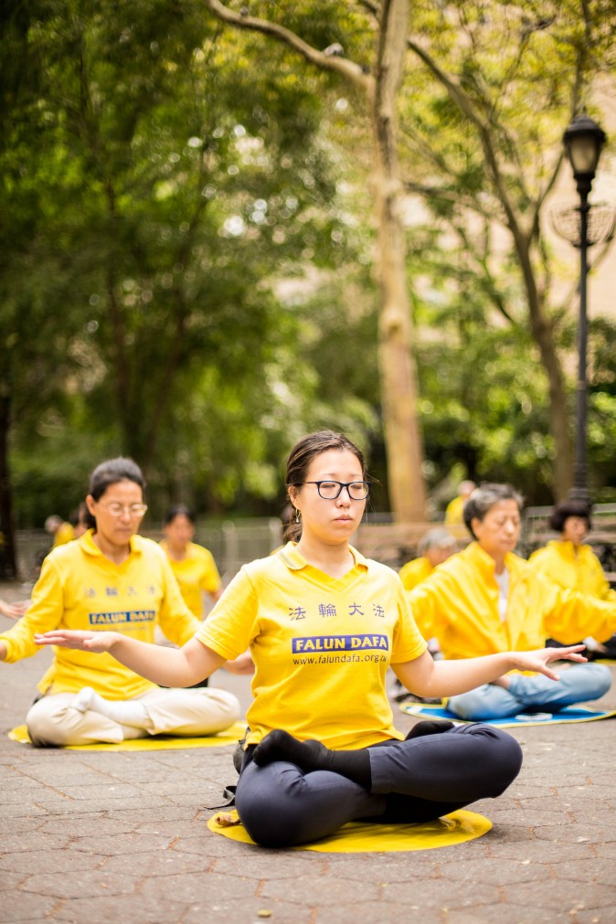 Falun Gong practitioners meditate to raise awareness about the persecution inside China that is now in its 18th year at the Dag Hammarskjold Plaza near the United Nations headquarters in New York while the world leaders meet on Sept. 19, 2017. (Benjamin Chasteen/The Epoch Times)