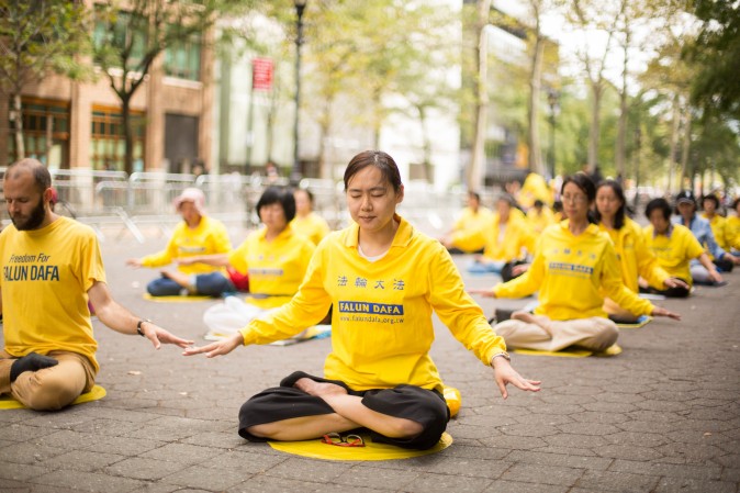 Falun Gong practitioners meditate to raise awareness about the persecution inside China that is now in its 18th year at the Dag Hammarskjold Plaza near the United Nations headquarters in New York while the world leaders meet on Sept. 19, 2017. (Benjamin Chasteen/The Epoch Times)