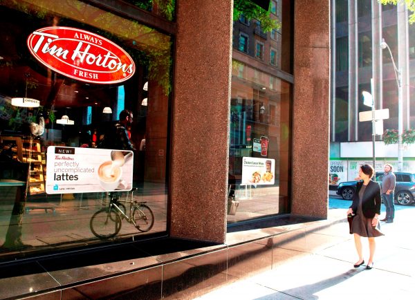 A woman walks past aÂ TimÂ HortonsÂ coffee shop in Toronto. (The Canadian Press/Doug Ives)