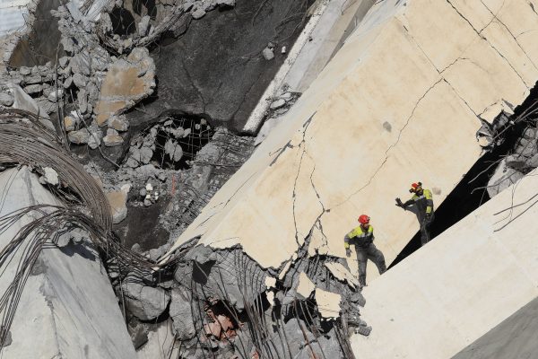 Rescuers scour rubble of the collapsed bridge for survivors