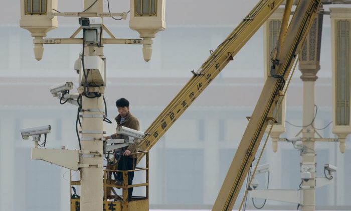 A man checks surveillance cameras on Tiananamen Square in Beijing on Oct. 31, 2013. (Ed Jones/AFP/Getty Images)