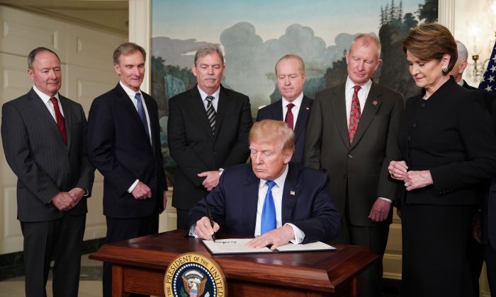 U.S. President Donald Trump signs trade sanctions against China in the Diplomatic Reception Room of the White House in Washington, D.C., on March 22, 2018.
(Mandel Ngan/AFP/Getty Images)
