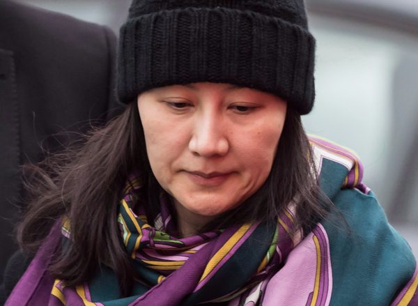 Huawei chief financial officer Meng Wanzhou is escorted by her private security detail while arriving at a parole office, in Vancouver, on Dec. 12, 2018. (The Canadian Press/Darryl Dyck)