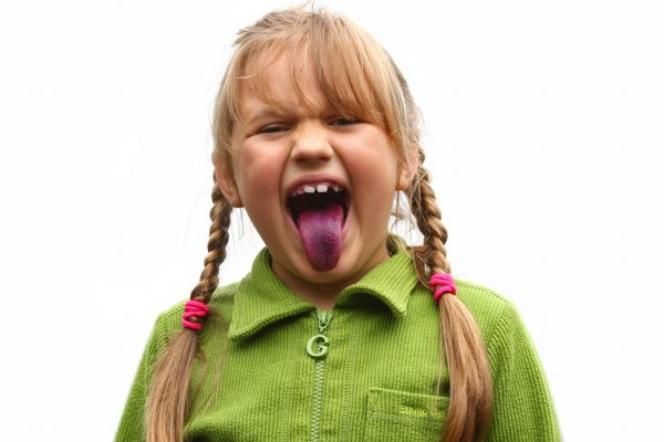 Girl showing her tongue after eating bilberries 