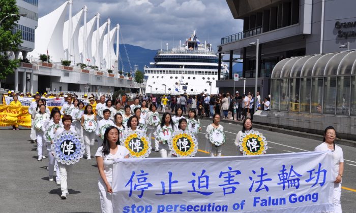 A procession of Falun Dafa adherents in white hold memorial wreaths to pay tribute to their fellow practitioners who have died due to torture and persecution in China during a parade in downtown Vancouver on July 16, 2017. (Tang Feng/The Epoch Times)