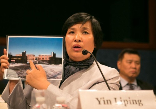 Falun Dafa practitioner Yin Liping shows a photo of Masanjia Labour Camp to congressional representatives at a hearing on Capitol Hill on April 14, 2016. Yin was a victim of torture and gang rape while incarcerated at Masanjia. (Minghui.org)