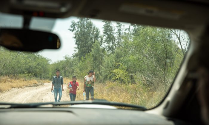 A group of unaccompanied minors seeks out Border Patrol after illegally crossing the Rio Grande from Mexico into the United States in Hidalgo County, Texas, on May 26, 2017. (Benjamin Chasteen/The Epoch Times)