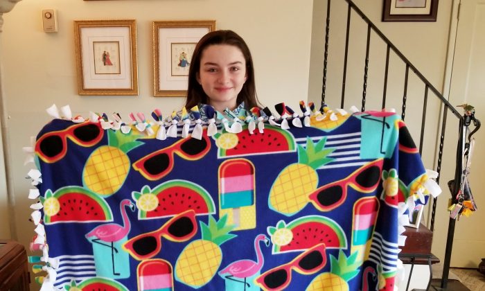 Meredith Kass, a senior at Kellenberg Memorial High School in Uniondale, N.Y., holds a Meredith's Favorite Blanket to help those in need. (Photo by Rolyne Joseph)