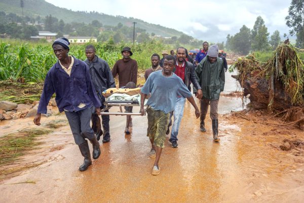 A rescued man is seen carried on a stretcher b