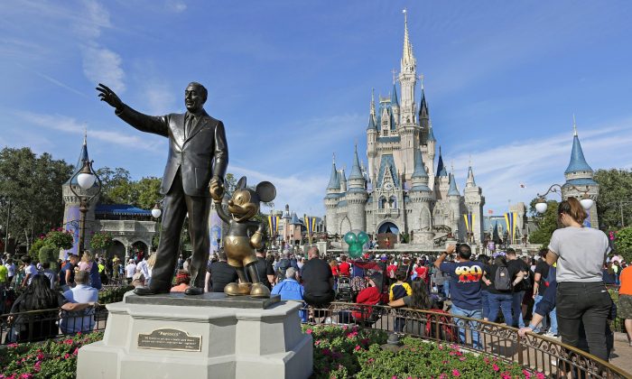 Guests watch a show near a statue of Walt Disney and Micky Mouse in front of the Cinderella Castle at the Magic Kingdom at Walt Disney World in Lake Buena Vista, Fla., on Jan. 9, 2019. (John Raoux/AP Photo)