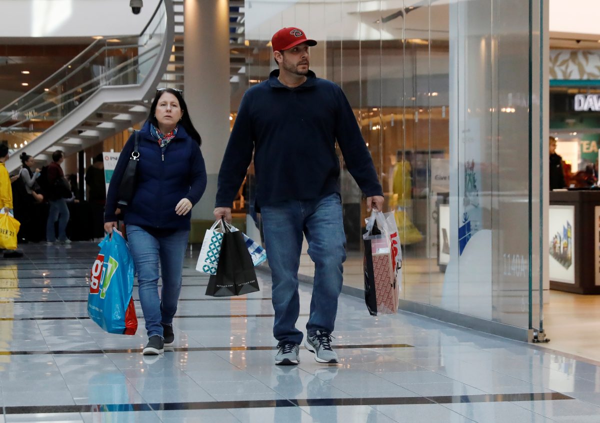 People walk with shopping bags at Roosevelt Field in Garden City