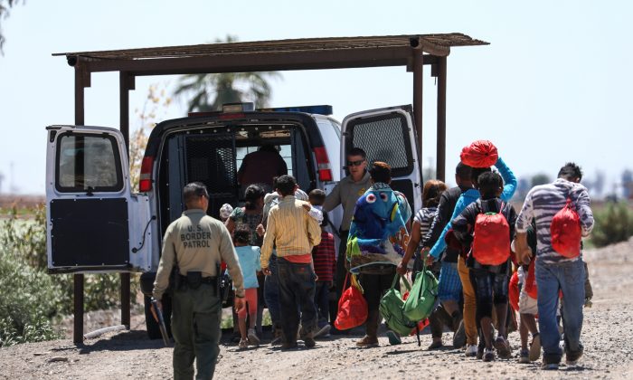 A group of illegal aliens is processed by Border Patrol agents after crossing from Mexico into Yuma, Ariz., on April 13, 2019. (Charlotte Cuthbertson/The Epoch Times)