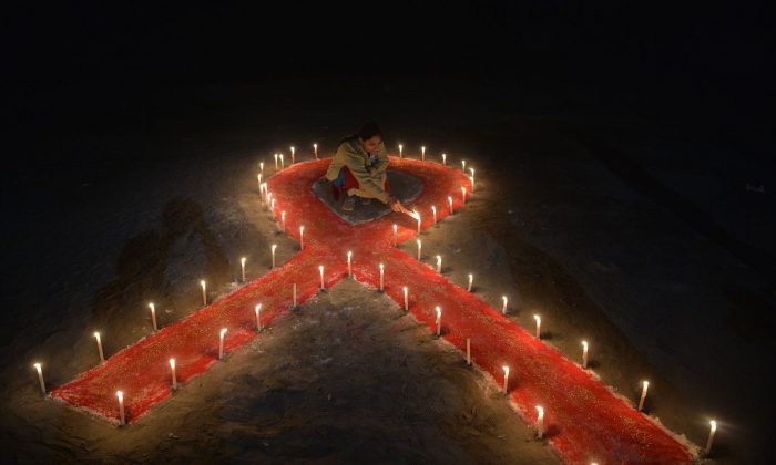 An person lights candles forming the shape of a ribbon as part of World AIDS Day in Siliguri, West Bengal, India, on Dec. 1, 2018. (Diptendu Dutta/AFP/Getty Images)