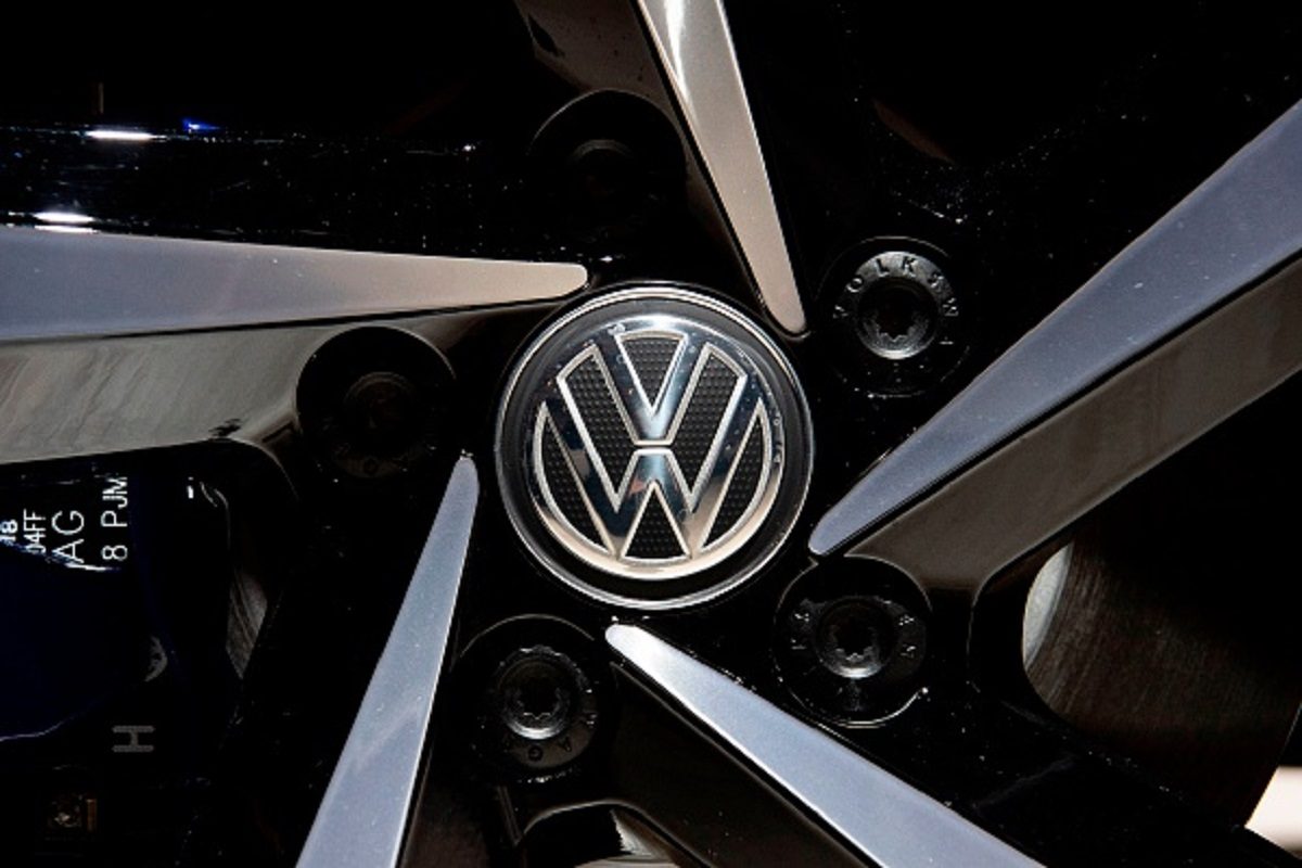 A Volkswagen logo appears on the wheel of a VW Passat GTE Variant on display