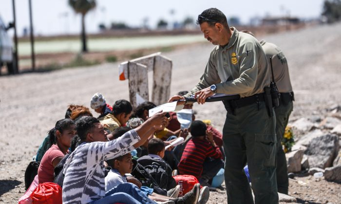 A group of illegal aliens is processed by Border Patrol agents after crossing from Mexico into Yuma, Ariz., on April 13, 2019. (Charlotte Cuthbertson/The Epoch Times)