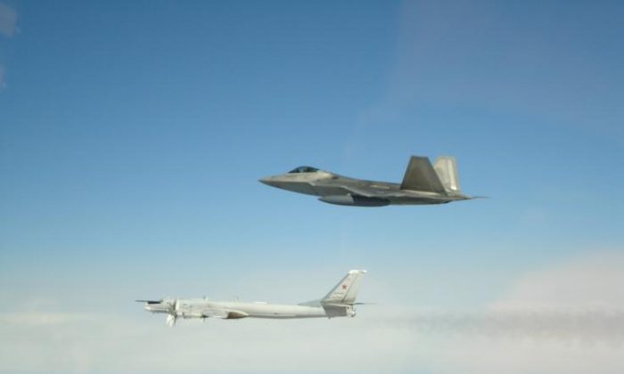 A Russian Tupolev Tu-95 strategic bomber and missile carrier (L) is seen being accompanied by a U.S. F-22 fighter jet in international airspace off the coast of Alaska, on May 21, 2019. (NORAD)