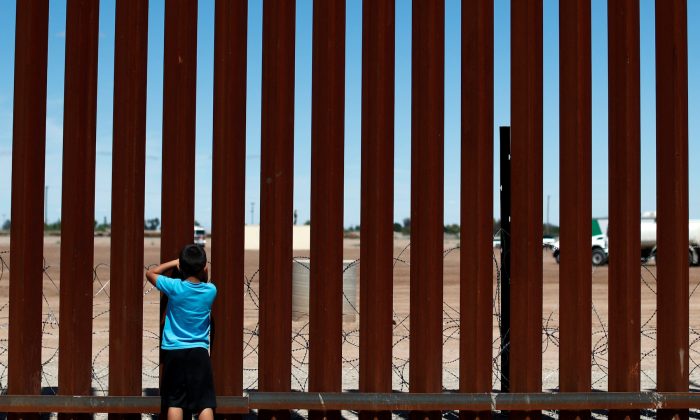 A child looks through the border wall during the visit of U.S. President Donald Trump to Calexico, California, as seen in Mexicali, Mexico, on April 5, 2019. (Reuters/Carlos Jasso)