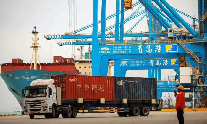 A staff member watches over a truck as he talks on his interphone at a port in Qingdao City, Shandong Province, China, on November 8, 2018. STR/AFP/Getty Images