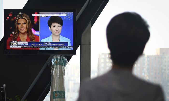 China's state broadcaster CGTN anchor Liu Xin looks at a screen showing her debate with Fox Business Network presenter Trish Regan, at the CCTV headquarters in Beijing on May 30, 2019. (Wang Zhao/AFP/Getty Images)