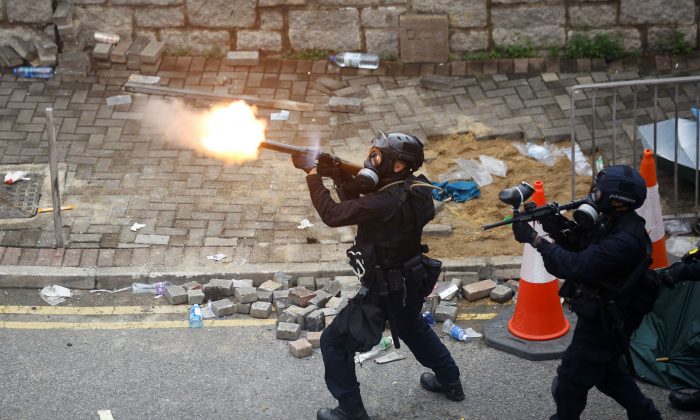 Police officer fires tear gas at protesters during a demonstration against a proposed extradition bill in Hong Kong, China, on June 12, 2019. (Thomas Peter/Reuters)