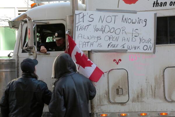 A trucker talks with members of the public in the center of Ottawa on Feb. 11, 2022. (Richard Moore/The Epoch Times)