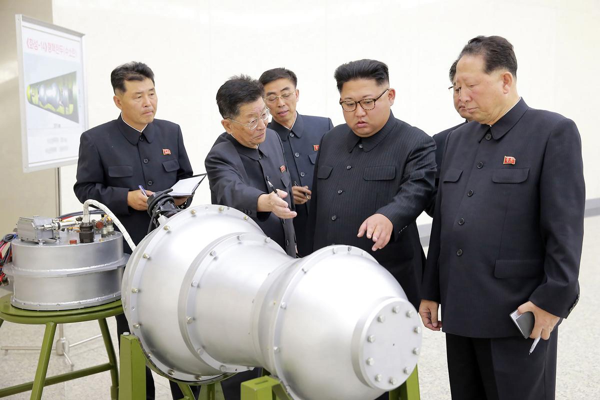 A picture released by North Korean state media showing dictator Kim Jong-un standing next to what appears to be a miniaturized version of a nuclear bomb. (STR/AFP/Getty Images)