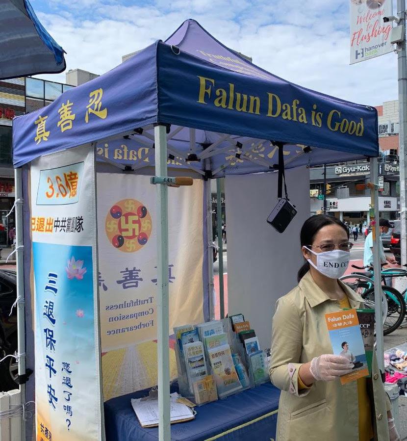 Falun Gong practitioner Xiao Ping in front of a booth where she raises awareness about China's persecution of the spiritual practice, in Flushing, New York, on Oct. 1, 2020. (Provided to The Epoch Times)