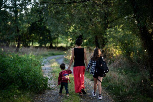 A mother walks toward school with her children in Lavau-sur-Loire, western France, on Sept. 2, 2021 (Loic Venance/AFP via Getty Images)