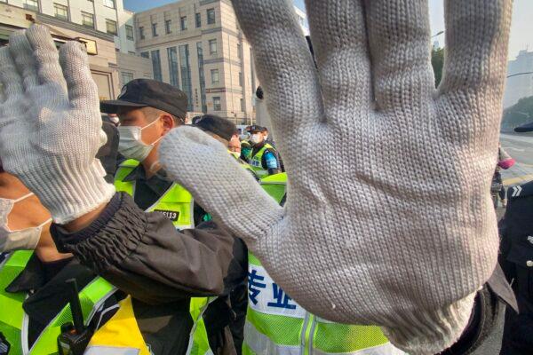 A policeman blocks the camera to stop journalists from recording footage outside the Shanghai Pudong New District People's Court, where Chinese citizen journalist Zhang Zhan—who reported on Wuhan's COVID-19 outbreak and was placed under detention since May 2020—is set for trial in Shanghai on Dec. 28, 2020. (LEO RAMIREZ/AFP via Getty Images)