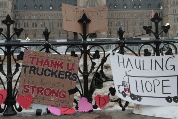 Signs supporting the Freedom Convoy 2022 adorn fences along Wellington St in the centre of Ottawa on Feb. 12. (Richard Moore/The Epoch Times)